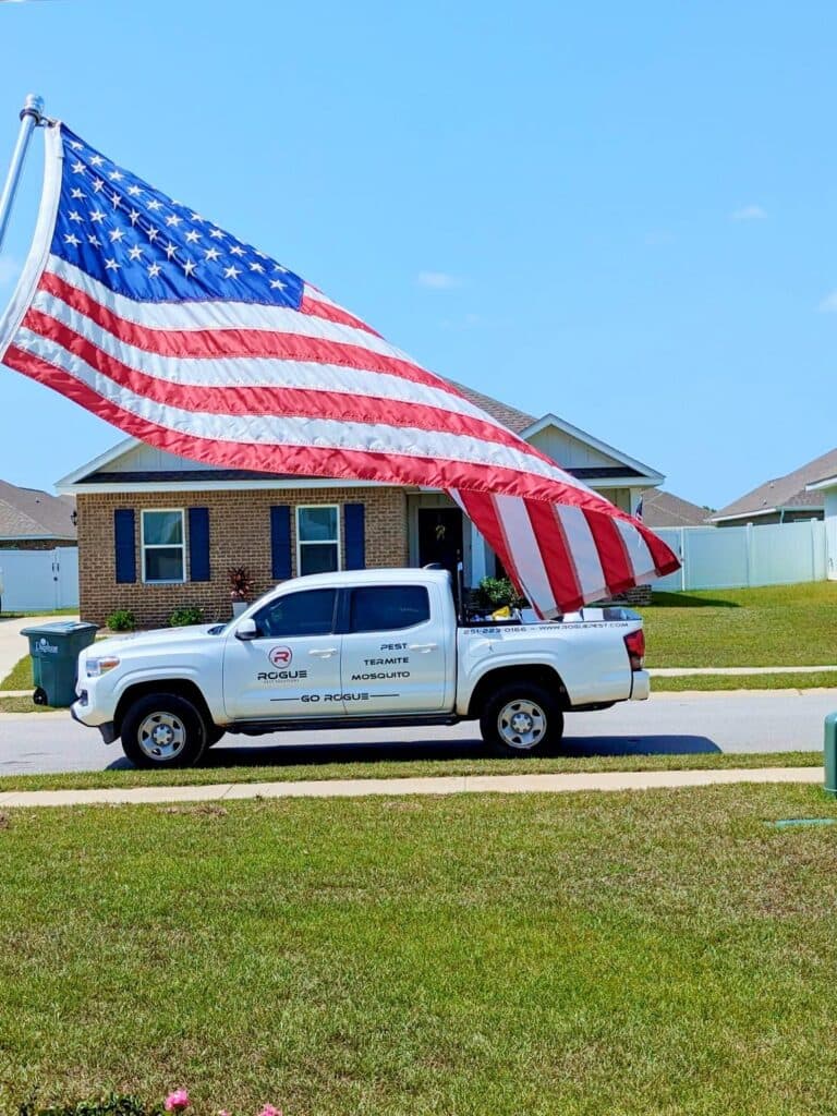 American flag beside a Rogue Pest Solutions service truck